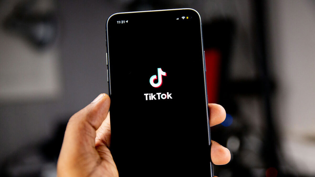 TikTok logo on a phone screen in somebody's hand