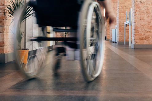Photo of a wheelchair moving down a corridor