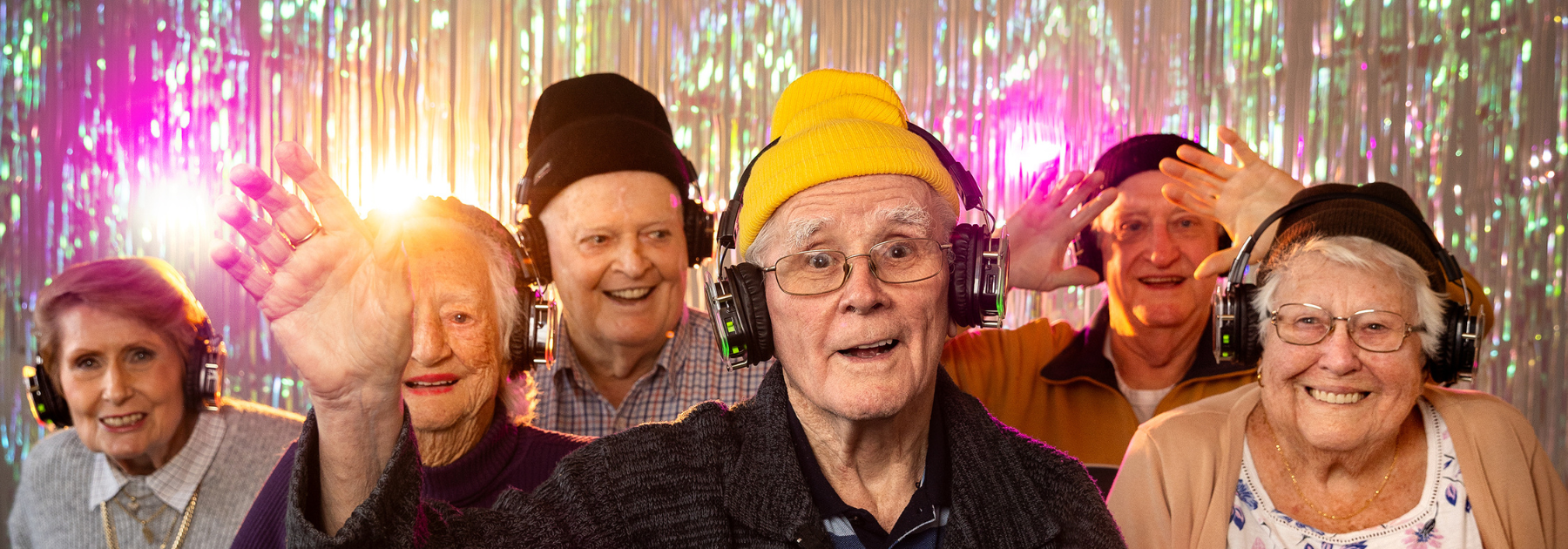 Aged care residents having a disco wearing headphones