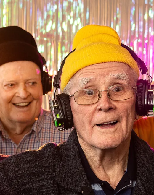 Aged care residents having a disco wearing headphones